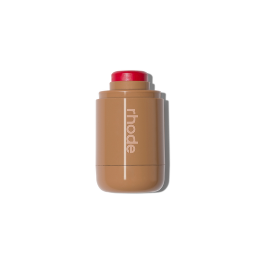 Rhode lip balm stick with creamy texture and vibrant red cap, luxury beauty essential