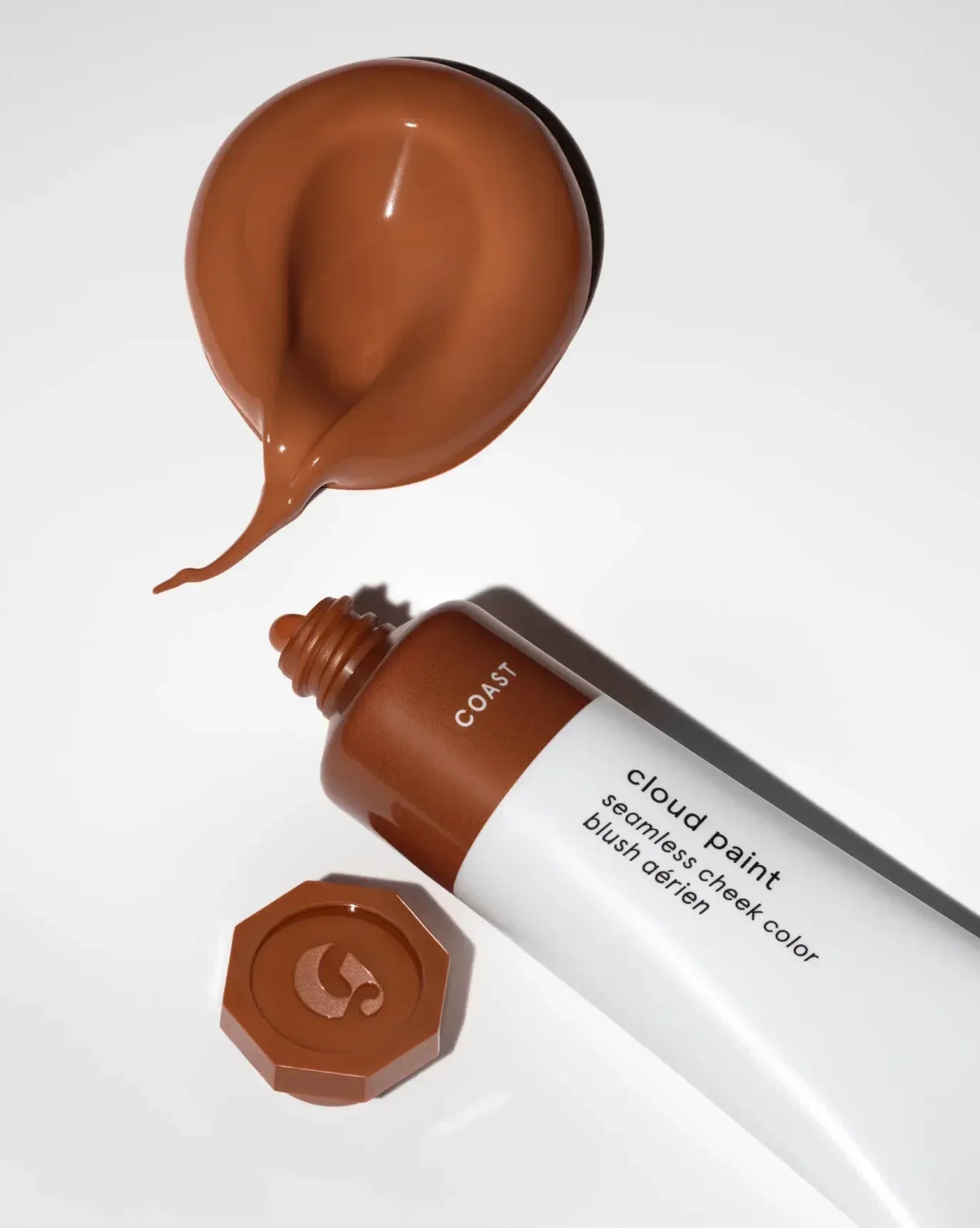 Creamy, rich bronze liquid blush with dewy finish from a stylish white tube on white background.