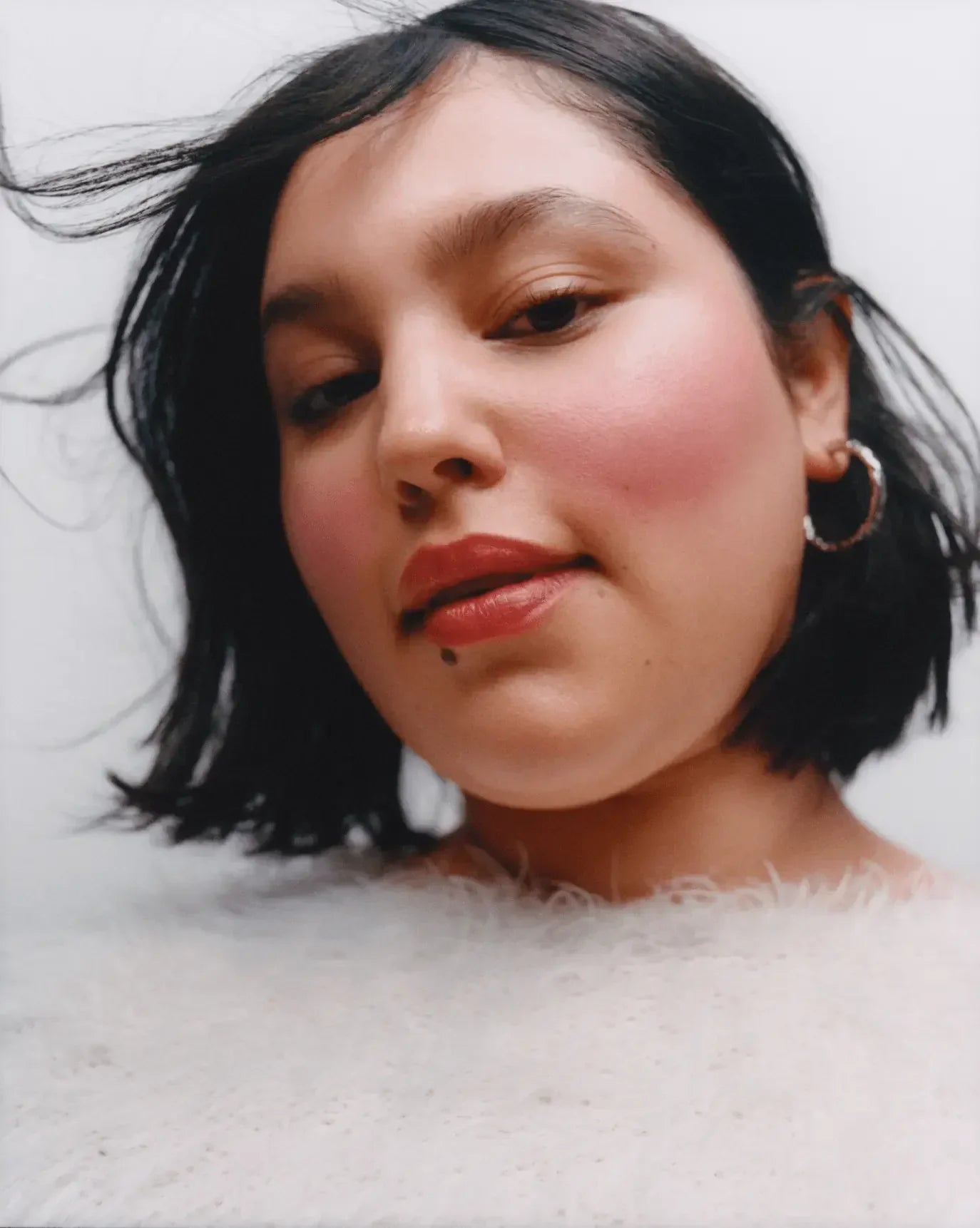 Woman wearing soft pink blush with a dewy finish and creamy texture, elegant makeup look