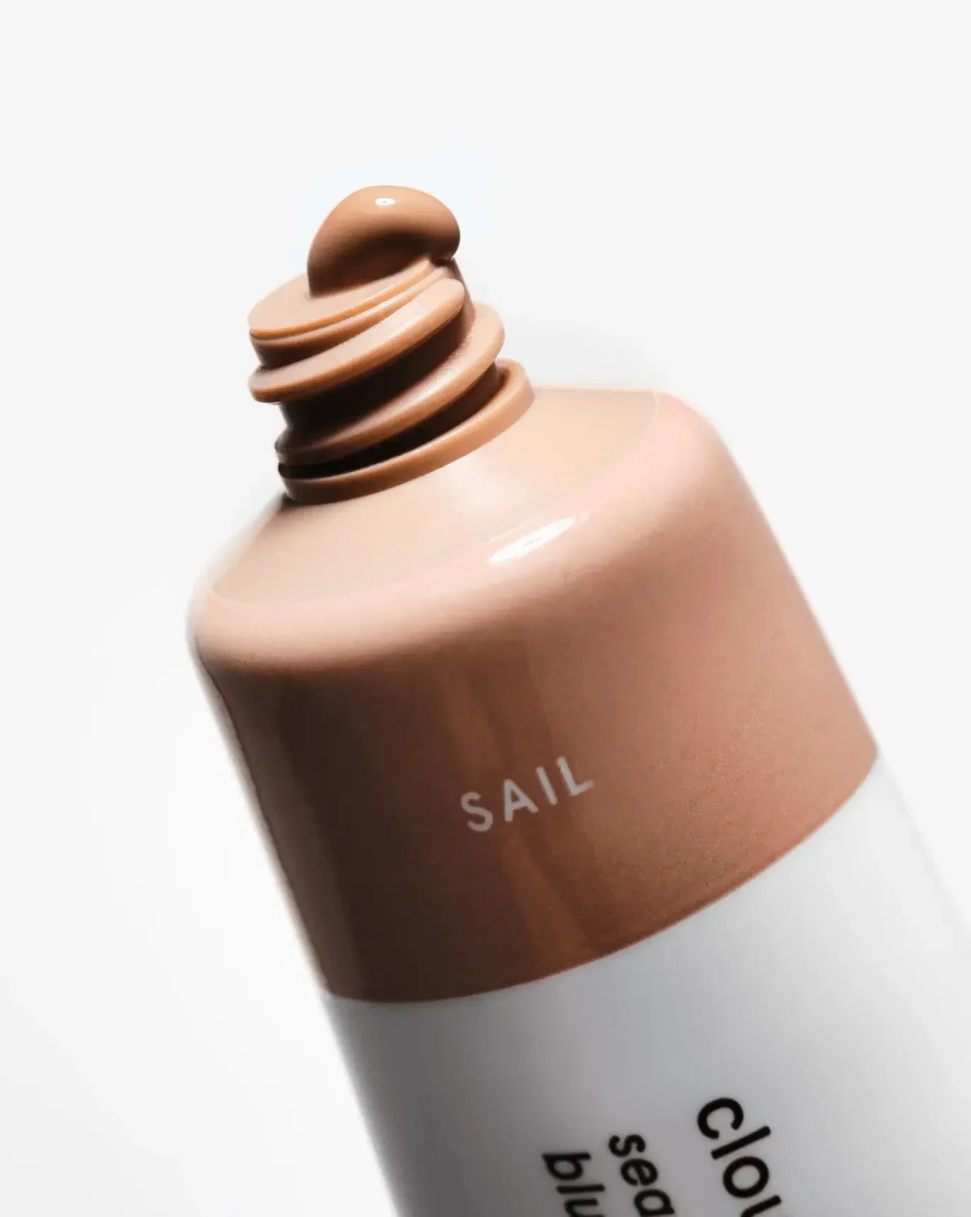 Creamy peach nude liquid blush with dewy finish, tube labeled 'SAIL', on white background