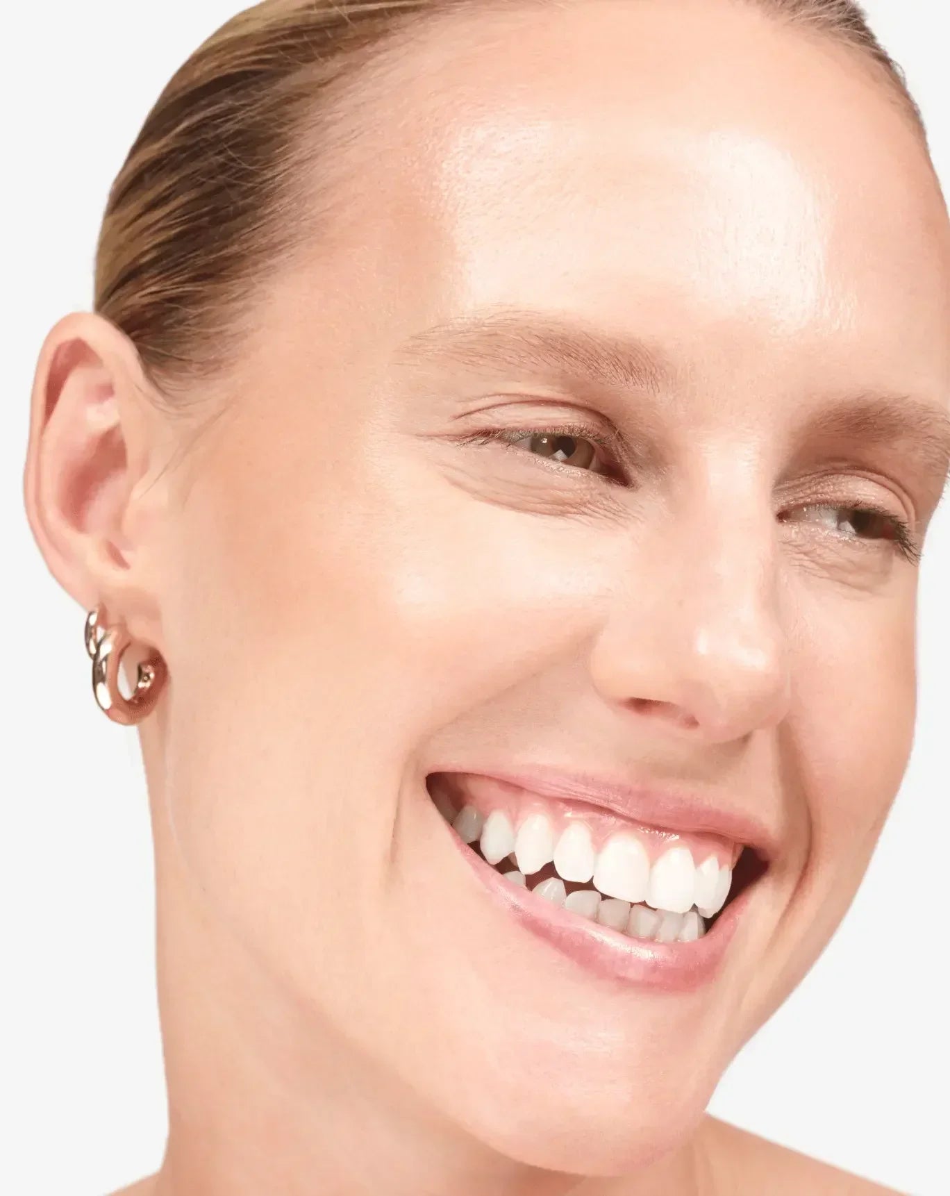 Woman with radiant, glowing skin and natural makeup, showcasing dewy complexion and minimal look.