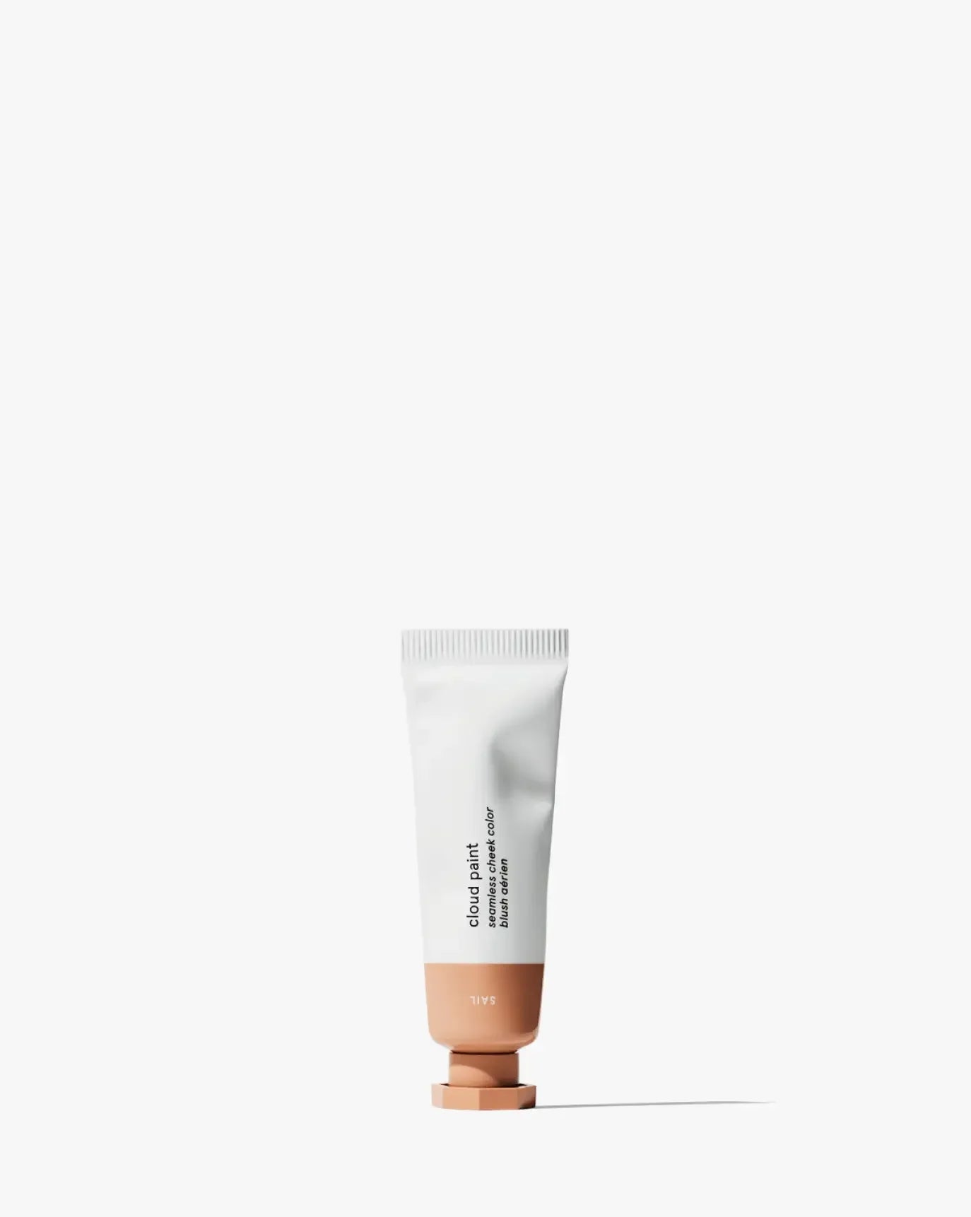 Cream blush tube in a soft peach shade with a dewy, luxurious finish on a white background.