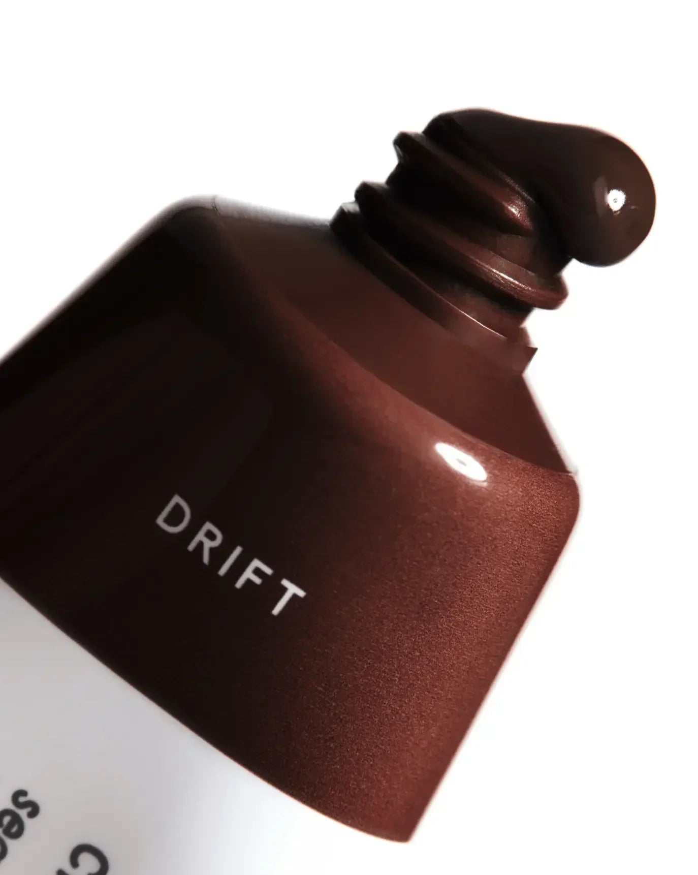 Deep berry cream blush with a smooth, dewy finish squeezed from a tube labeled Drift.