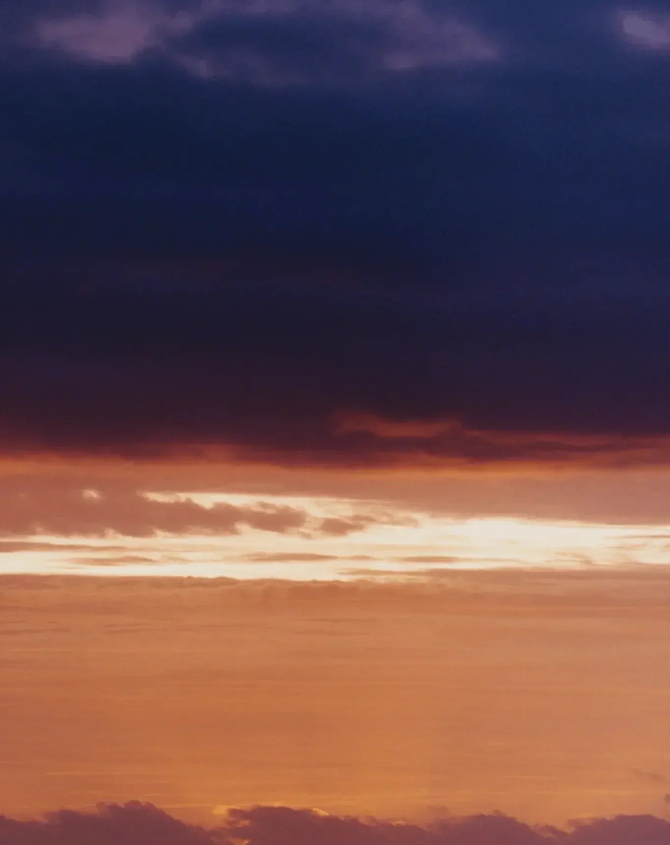 Vivid sunset sky with gradient orange and purple clouds, creating a dramatic luxurious atmosphere.