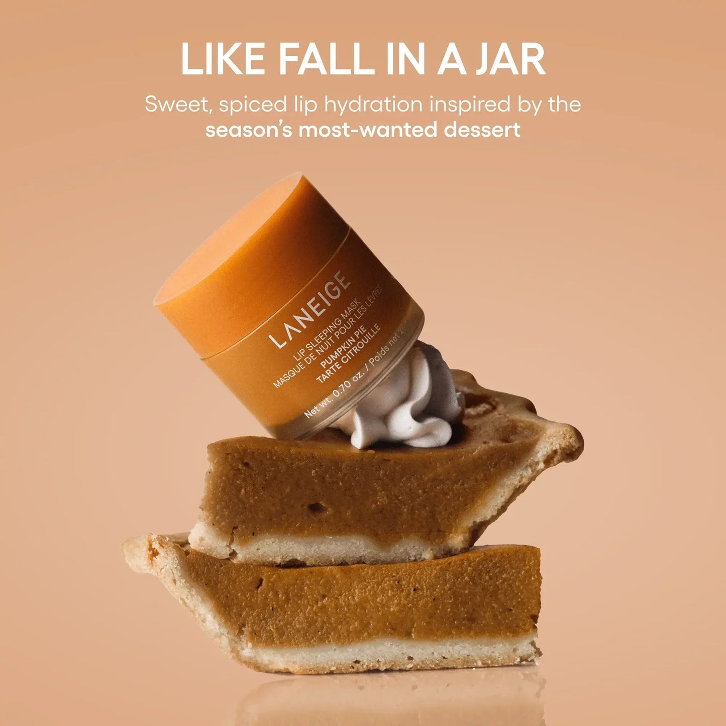 Pumpkin-colored Laneige lip sleeping mask jar with creamy texture, atop pumpkin pie slices.