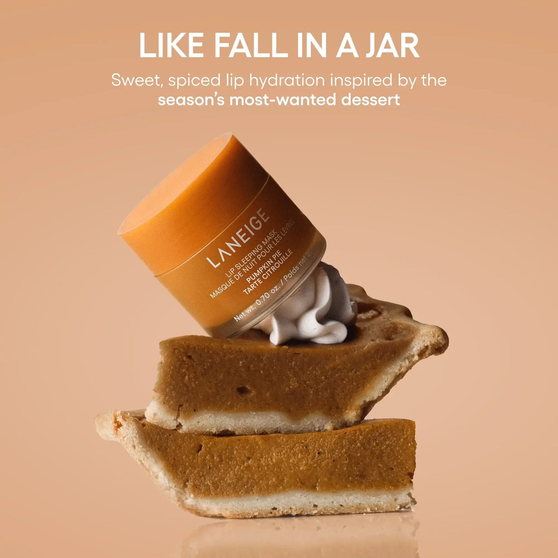 Pumpkin-colored Laneige lip sleeping mask jar with creamy texture, atop pumpkin pie slices.
