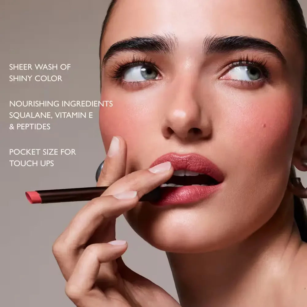Model with smooth skin applies rosy lip color, showcasing dewy finish and pocket-sized beauty stick