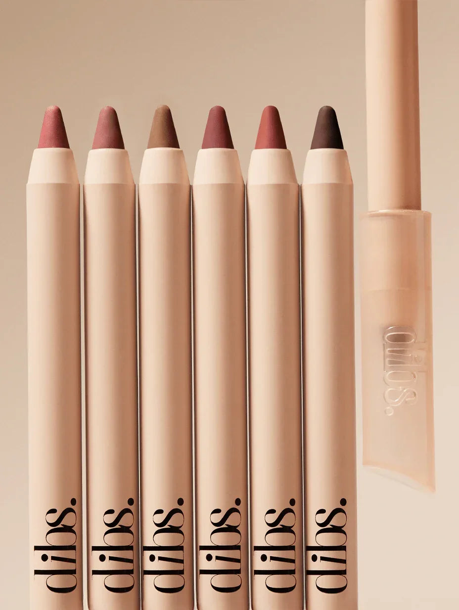 DIBS creamy nude and pink tone lip liners displayed in a chic, neutral setting.