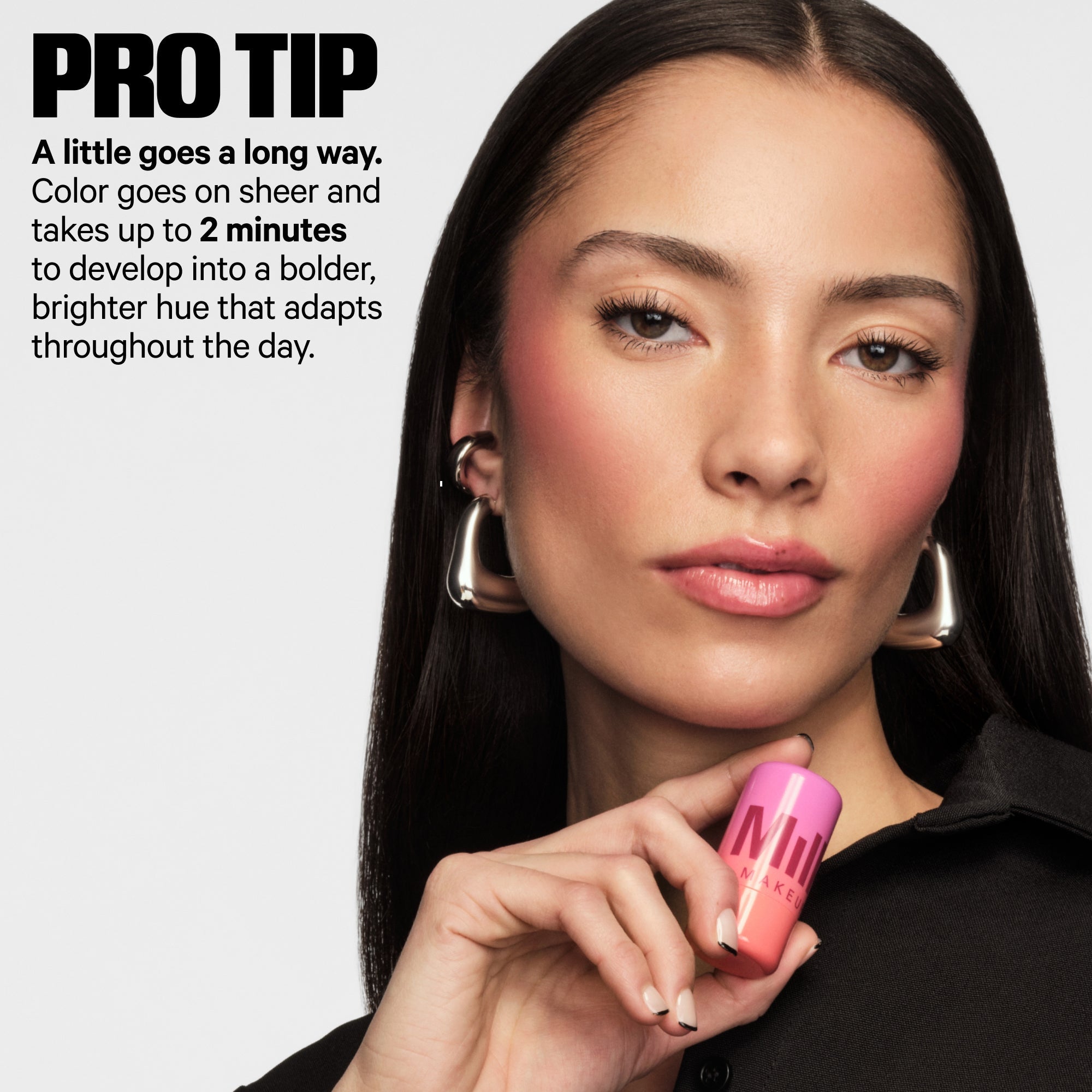 Woman holding pink Milk Makeup PH Jelly Tint blush with radiant cheeks, bold blush makeup look