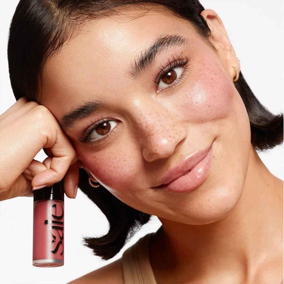 Model with radiant skin showcasing rosy dewy blush and creamy liquid cheek color