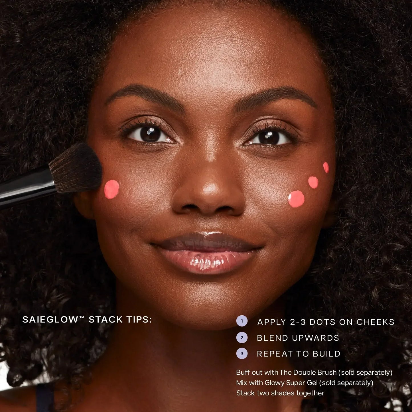 Model with glowing skin applies dewy peach blush dots on cheek using makeup brush