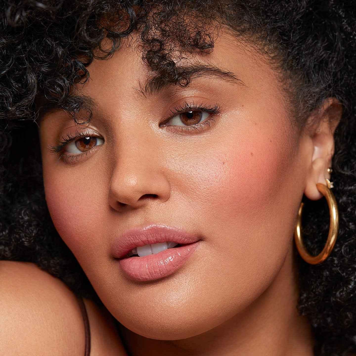 Model with radiant dewy blush, soft pink cheeks, and luminous skin texture