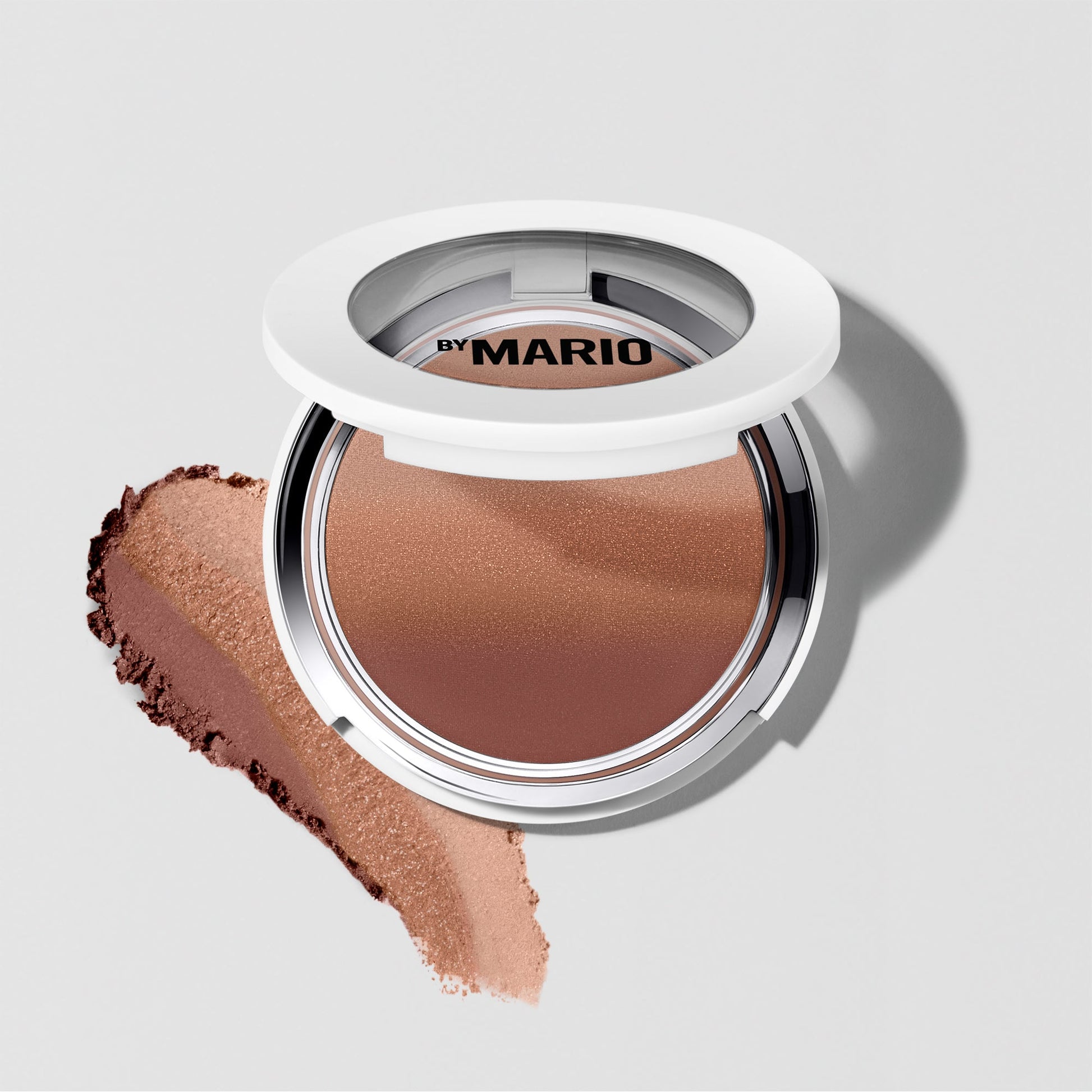 Pressed powder bronzer in rich medium-dark shade with soft matte finish in white compact