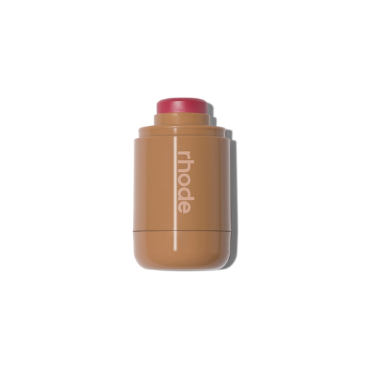 Rhode creamy blush stick in rosy pink, sleek tan tube, dewy finish