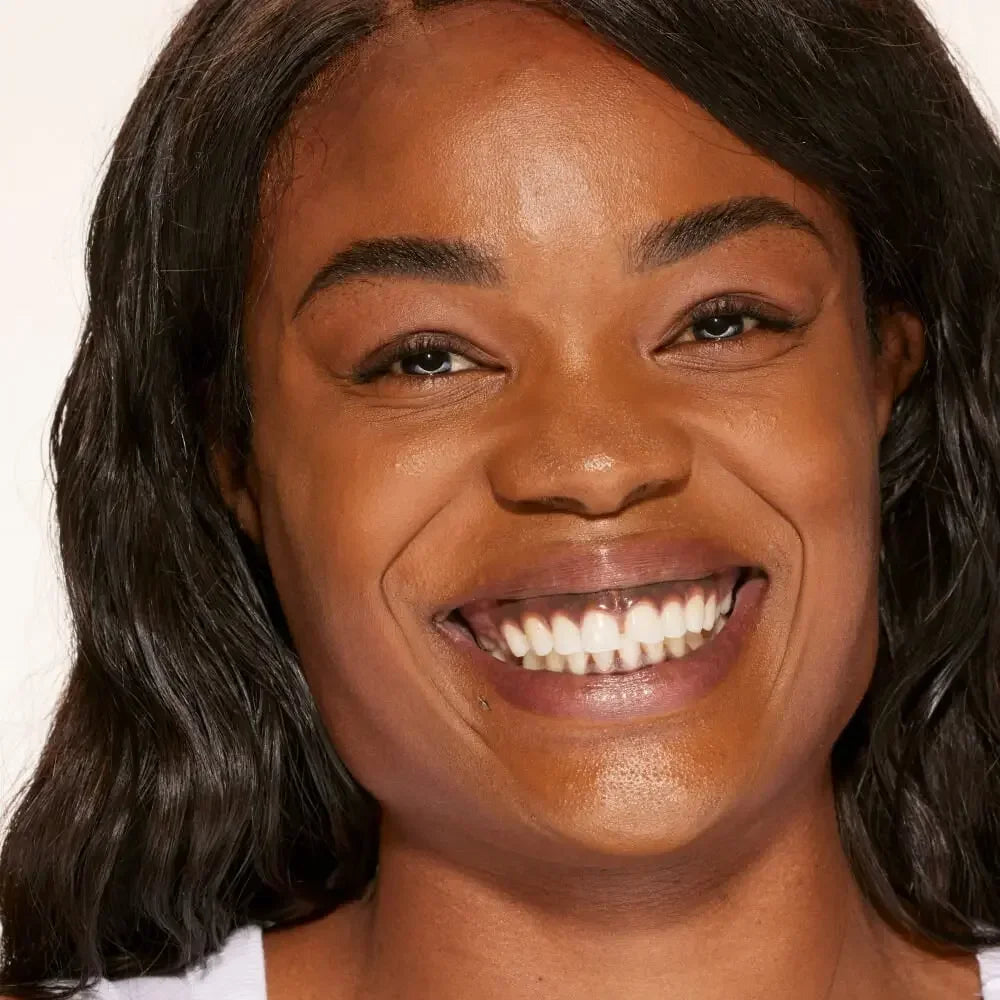 Close-up of woman with radiant deep complexion and natural, dewy makeup finish
