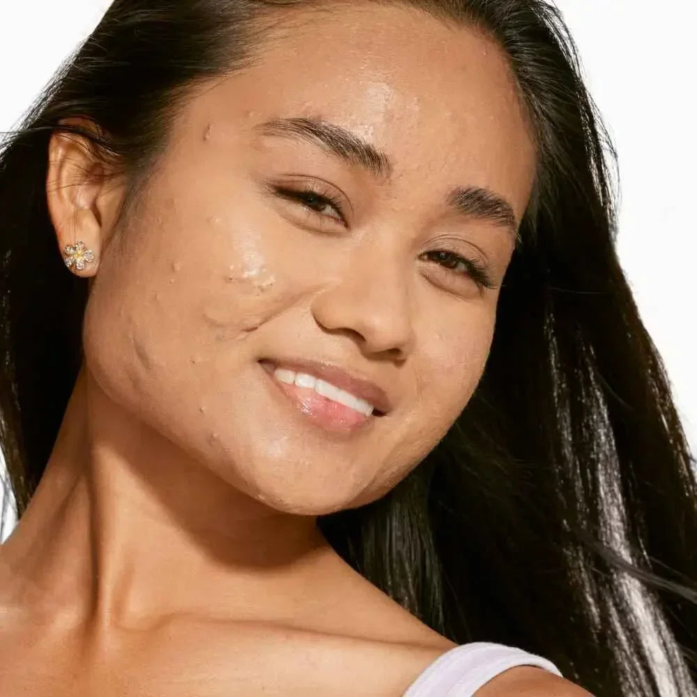 Woman with radiant, dewy finish complexion showing creamy concealer on textured skin
