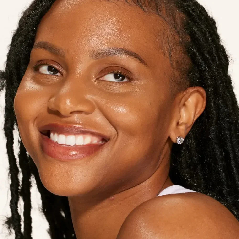 Woman with radiant, even complexion and dewy finish, showcasing natural makeup look